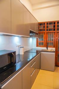a kitchen with stainless steel appliances and wooden cabinets at Villa Elegant Oasis in Horana