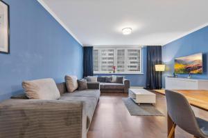 a living room with a couch and a table at Tomato Apartment - With free parking in Bratislava +4 photos