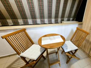 two chairs and a table with a book on it at Tirana Center - AAL in Tirana +3 photos