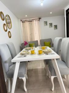 Una mesa de comedor blanca con sillas y una mesa blanca. en Apartamento al frente del hospital san jose y la facultad de medicina, en Popayán 18 fotos más