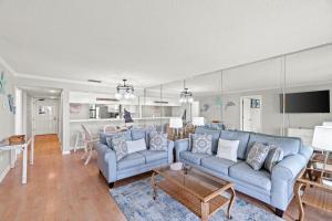 a living room with two blue couches and a kitchen at Edgewater Golf Villa 1210 in Panama City Beach