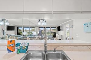 a kitchen with a sink and a living room at Edgewater Golf Villa 1210 in Panama City Beach