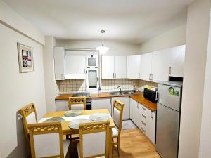 a kitchen with a table and chairs and a kitchen with white cabinets at Tirana Center - AAL in Tirana
