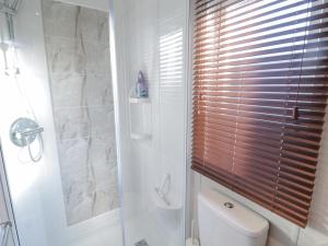 a bathroom with a toilet and a shower with a window at Downtime Lodge in Morpeth +17 photos