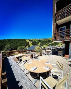 eine Terrasse mit einem Holztisch und Stühlen in der Unterkunft Hotel Perdrix in Super Besse