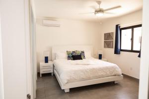 een slaapkamer met een wit bed en een raam bij Casa De lo Mio in Sosúa +16 foto's