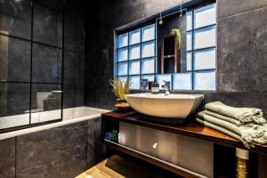 a bathroom with a sink and a tub at Stay In Style At Olive 77 Book Your Trip Now in Hanwell +86 photos