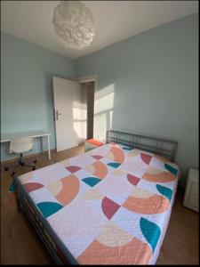 a bedroom with a bed with a quilt on it at Chambre confortable lits double schaarbeek premier étage in Brussels