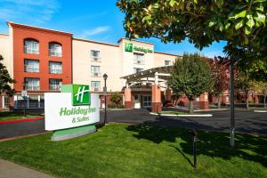 a hotel with a sign in front of a building at Holiday Inn & Suites San Mateo - SFO by IHG in San Mateo