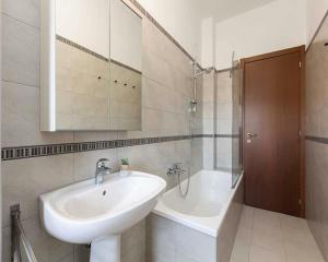 a white bathroom with a sink and a bath tub at City Centre Accommodation in Dublin