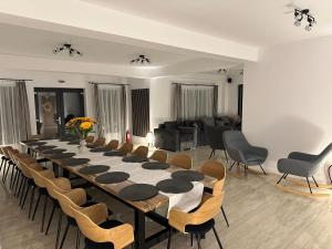 a long table and chairs in a room at Casa David Valea Avrigului in Avrig +59 photos