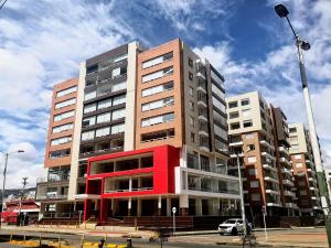 Un edificio alto con una fachada roja en una calle. en Hotel GHR INTERNACIONAL, en Tunja