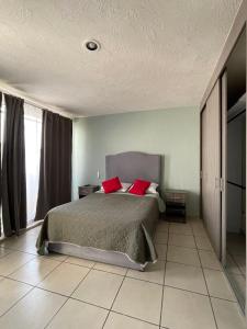 a bedroom with a bed with red pillows on it at 2 VENATOR House Boutique in León
