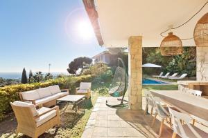 a patio with a table and chairs and a pool at Chez Pablo Barcelona in Cabrils