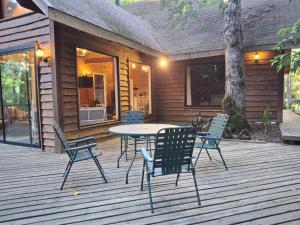 a patio with a table and chairs on a deck at Quebrada del Chucao in Pucón