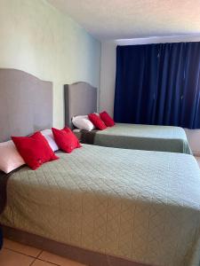 two beds with red pillows in a room at 4 VENATOR House Boutique in León +2 photos