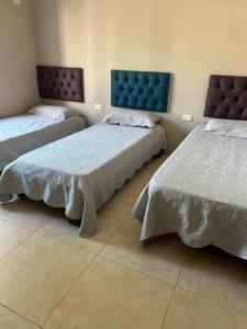 a bedroom with two beds and a blue headboard at Casa Quinta Los Arandanos in San Geronimo