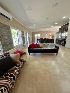 a living room with two couches and a kitchen at Casa Quinta Los Arandanos in San Geronimo