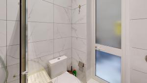 a bathroom with a toilet and a glass shower at Seaside Apartment Steps Away From The Sea in Il-Gżira