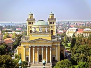 duży żółty budynek z wieżą na górze w obiekcie Csillagfény Apartment w Egerze