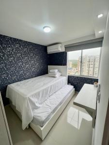 une petite chambre avec un lit et une fenêtre dans l'établissement Nuevo apartamento de lujo con balcón wifi AC piscina, à Barranquilla 21 autres photos