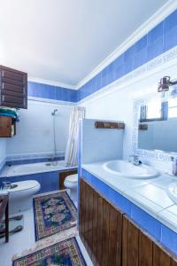a blue and white bathroom with a sink and a toilet at Casa Rural La Casona in Casas de Juan Núñez