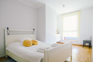 a white bedroom with two donuts on a bed at NORDA Apartamenty SEA TOWERS Gdynia in Gdynia