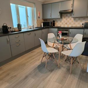 a kitchen with a glass table and chairs at Ghyll Rigg in Bowness-on-Windermere +15 photos
