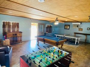 a room with a pool table and two tables at Waterfront Prairie Flower Treehouse in Seguin