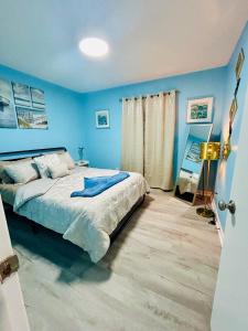 Un dormitorio con paredes azules y una cama grande. en Coastal Retreat Near Pineville and CLT, en Charlotte