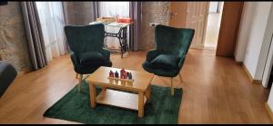 zwei Stühle und ein Couchtisch in einem Wohnzimmer in der Unterkunft Casasoutelo in Carrazedo