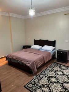 a bedroom with a bed with two tables and a rug at Doven Farm in Wadi Musa