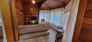 a living room with a couch and a television at Pousada Villeta Di Itália in Santa Teresa