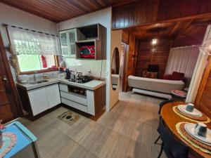 a kitchen with a sink and a couch in a room at Pousada Villeta Di Itália in Santa Teresa
