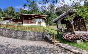 a house with a stone wall and a fence at Pousada Villeta Di Itália in Santa Teresa