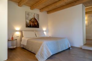 ein Schlafzimmer mit einem Bett und einem Gemälde an der Wand in der Unterkunft Corte La Pellegrina in Caprino Veronese