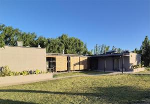 a building with a grassy field in front of it at casArtero eco posada in San Rafael