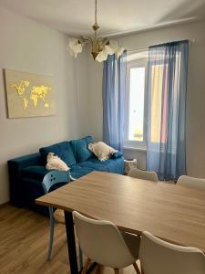a living room with a table and a blue couch at Collie’s place in Koper