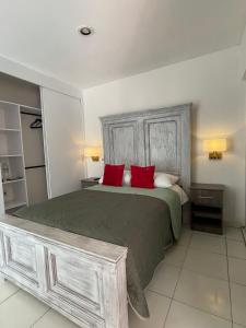 a bedroom with a large bed with red pillows at 12 VENATOR House Boutique in León