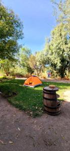 an orange tent and a barrel in a park at Quinta El Cocula camping, cabañas y eventos in San Miguel +4 photos