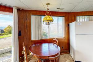a dining room with a table and a refrigerator at Carousel House in Pacific City in Pacific City