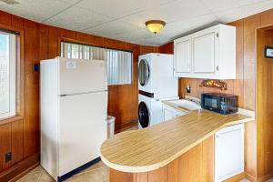 a kitchen with a white refrigerator and a counter top at Carousel House in Pacific City in Pacific City