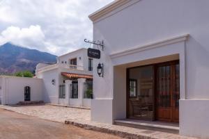 蒂尔卡拉Hotel El Candil Tilcara的街道上一扇带门的白色建筑