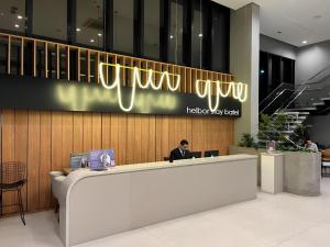 a man sitting at a reception desk in a lobby at Studio Helbor Stay Batel - Sofisticação, Conforto, Localização e Vista Privilegiada in Curitiba