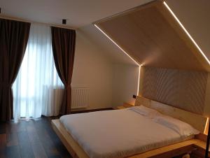 Un dormitorio con una cama grande y una ventana en Julien House, en Prisaca Dornei 37 fotos más