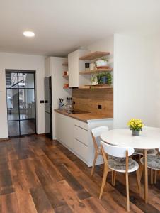 Una cocina y un comedor con mesa y sillas. en Julien House, en Prisaca Dornei