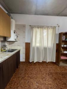 a kitchen with a white curtain in a room at Casagrande Navarro in Navarro