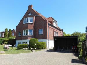 a large brick house with a garage in front of it at Apartments mit Flair in Fehmarn