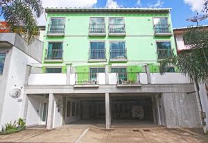 un edificio de apartamentos con un aparcamiento enfrente en Aventureiro Pousada en Teresópolis