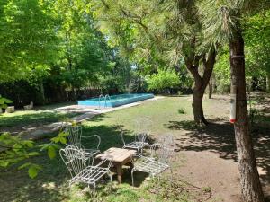 a picnic table and chairs next to a pool at EL LOTE DE VERO in Las Compuertas